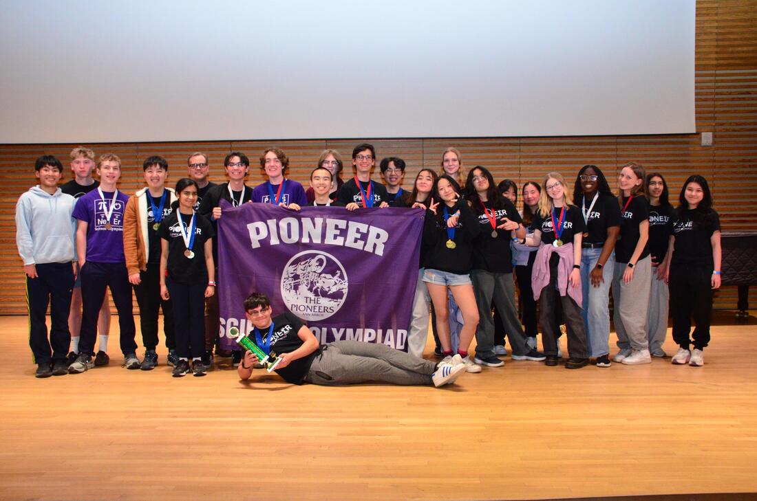 Pioneer Science Olympiad team photo on a stage with a purple team banner.